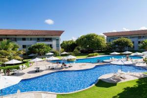 an overhead view of a resort pool with tables and umbrellas at Praia dos Carneiros Flat 206 C in Tamandaré