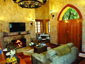 a living room with a couch and a fireplace at Pousada do Castelo in Monte Verde