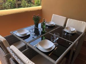 a table with plates and wine glasses on it at La Cala Azul 2 bedroom apartment with big sunny terrace & walking distance to all the amenities - costa del sol in La Cala de Mijas