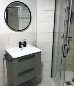 uma casa de banho com um lavatório, um espelho e um chuveiro em Acogedor apartamento en Llivia em Llivia