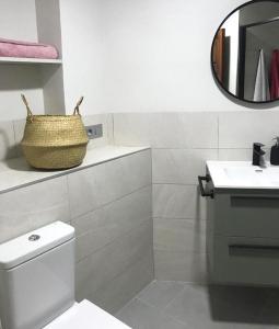 uma casa de banho com um WC, um lavatório e um espelho. em Acogedor apartamento en Llivia em Llivia