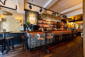 eine Bar in einem Restaurant mit Hockern in der Unterkunft Madrid Suites in Maastricht