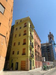 a yellow building on a street with a church at Sampedor Apartment in Valencia