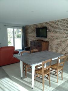 Frangy-en-Bresse的住宿－Gîte au bord de la rivière，客厅配有桌椅和砖墙