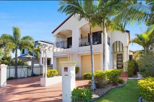 a house with palm trees in front of it at Large, Light, dog friendly home 600m to Burleigh beach in Gold Coast