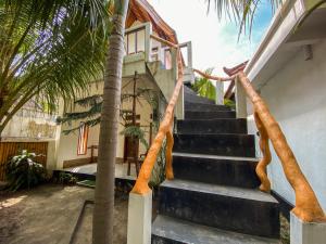 a staircase leading up to a house with palm trees at Gili Spoy-Spoy in Gili Islands
