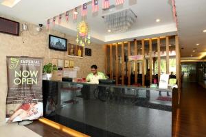 a man sitting at a counter in a restaurant at Uptown Imperial in Kajang