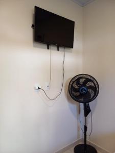a room with a fan and a tv on a wall at Recanto Sete Mares Hospedagem Familiar in Balneário Camboriú