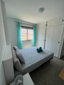 1 dormitorio con 1 cama con cortinas azules y ventana en VV_CMBAJAMAR, en Bajamar
