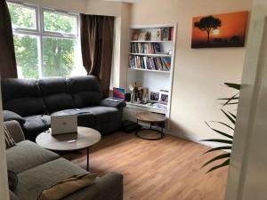 a living room with a couch and a table with a laptop at Strand Beach View House in Gillingham