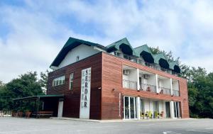 ein rotes Gebäude mit einem Dach darüber in der Unterkunft Hotel Serdar in Mojkovac