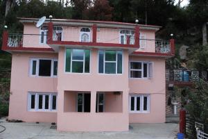Cette maison rose dispose d'un balcon. dans l'établissement THE BLISS HOME STAY, à Kalpa