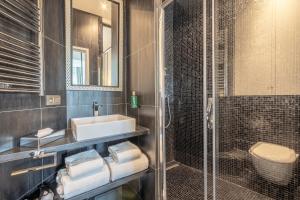 y baño con lavabo, aseo y ducha. en Yuna Les Halles - Serviced Apartments, en París