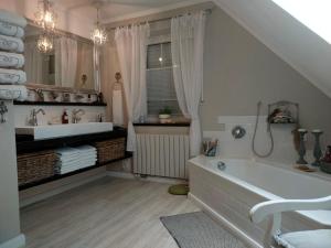 a bathroom with a bath tub and a sink at Luana`s White Cottage in Surwold