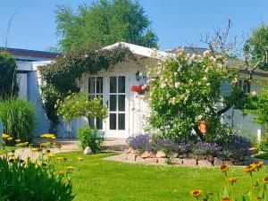a house with a garden with flowers in the yard at Luana`s White Cottage in Surwold