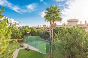 a tennis court in a park with palm trees at Lets in the Sun - Alamar La Cala de Mijas Apartments in La Cala de Mijas