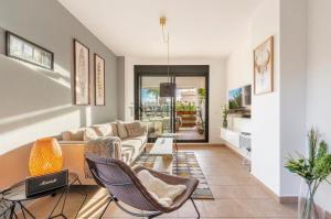 ラ・カラ・デ・ミハスにあるLets in the Sun - Alamar La Cala de Mijas Apartmentsのリビングルーム(ソファ、椅子付)