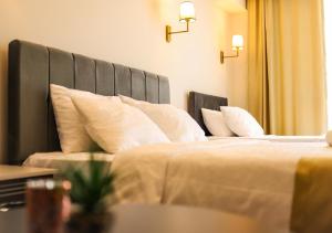 een slaapkamer met 2 bedden en witte kussens bij PETRA HOTEL TUZLA in Tuzla