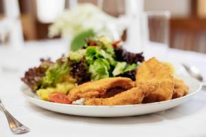 einen Teller mit Essen auf einem Tisch mit Salat in der Unterkunft Metzenhof in Kronstorf
