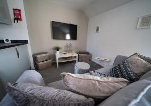 a living room with a couch and a tv at The Cosy Apartment Sherburn in Elmet in Sherburn in Elmet