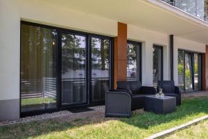 a screened in porch with chairs and a table at Little Laguna Apartments SPA & Gym by Renters in Międzywodzie