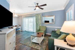 a living room with a couch and a flat screen tv at Coconut Palms Beach Resort II a Ramada by Wyndham in New Smyrna Beach