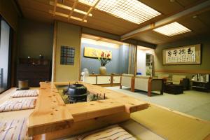 ein Wohnzimmer mit einem Tisch und einem Topf darauf in der Unterkunft Kinosaki Onsen Kawaguchiya Honkan in Toyooka
