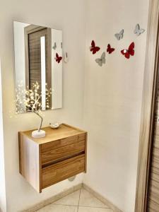 Raffadali的住宿－Casetta del Maestro，浴室设有镜子和蝴蝶,墙上