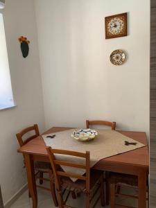 Raffadali的住宿－Casetta del Maestro，一张木桌,上面有两把椅子和盘子