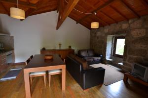 a living room with a table and a couch at Aldeia Turistica de Louredo in Vieira do Minho