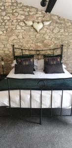 uma cama grande num quarto com uma parede de pedra em Monkton Court House B&B em Honiton