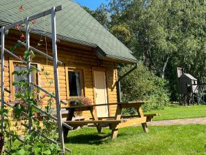 una cabaña de madera con un banco delante en Melluzi chalet en Jūrmala