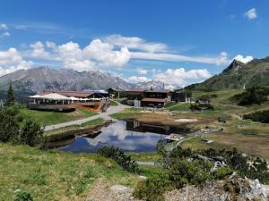 a building on a hill next to a body of water at Haus Mathies in Stuben am Arlberg