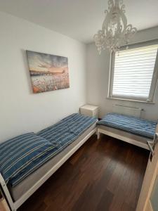 a bedroom with two beds and a chandelier at Apartament przy uzdrowisku. in Kamień Pomorski