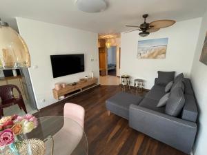 a living room with a couch and a tv at Apartament przy uzdrowisku. in Kamień Pomorski