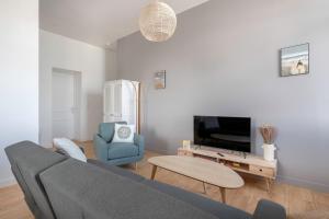 a living room with a couch and a tv at Bel appartement vue sur le port du Croisic in Le Croisic