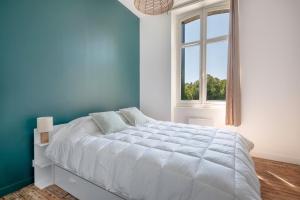 una camera blu con un grande letto e una finestra di Bel appartement vue sur le port du Croisic a Le Croisic