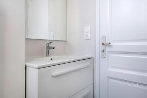 a white bathroom with a sink and a door at Bel appartement vue sur le port du Croisic in Le Croisic +16 photos