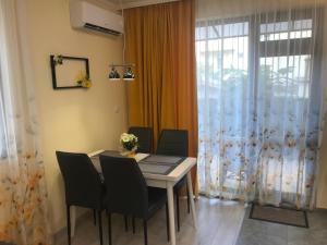 a dining room with a table and chairs and a window at Sunrise City A2, Sarafovo in Burgas