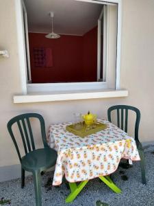 een tafel met twee stoelen en een gele pot erop bij JMC12 in Onet le Château