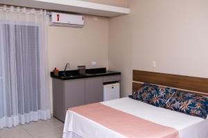 a bedroom with a bed and a counter at Hotel Vila ÁguaMar in Itapoa