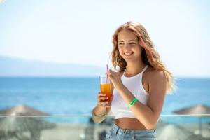 a young woman holding a drink in her hand at CHARM BEACH HOTEL in Akyarlar