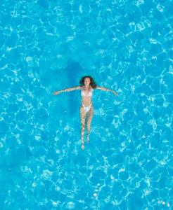 a woman floating in a pool of water at CHARM BEACH HOTEL in Akyarlar