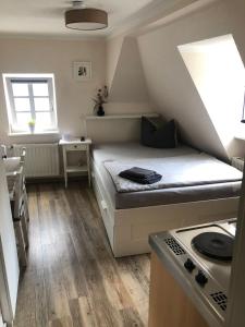 een kleine kamer met een bed en een fornuis bij Altstadt Pension Herborn in Herborn