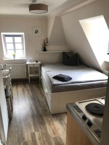 a small room with a bed and a stove at Altstadt Pension Herborn in Herborn