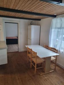 a kitchen with a table and chairs and a refrigerator at A cozy house to stay in Vandel