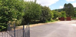 an empty parking lot with a fence and trees at Monkton Court House B&B in Honiton