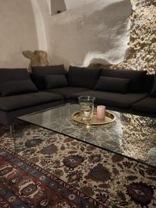 uma sala de estar com um sofá e uma mesa de vidro em La casa di mezzo em Calascio