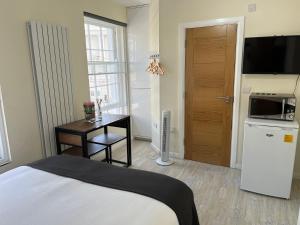 a bedroom with a bed and a table and a kitchen at Pods of Kings Cross 4 in London