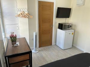 a small room with a refrigerator and a microwave at Pods of Kings Cross 4 in London